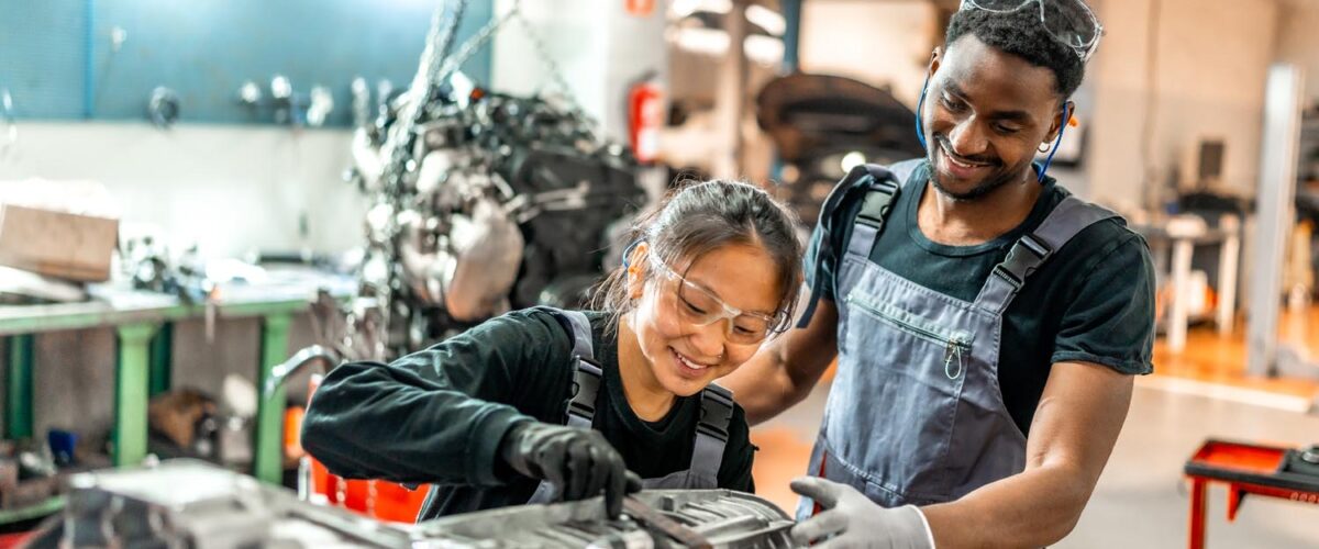 Mechanics working on vehicle engine in auto repair shop